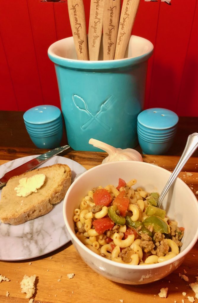 american chop suey new england style in a bowl with buttered bread on the side