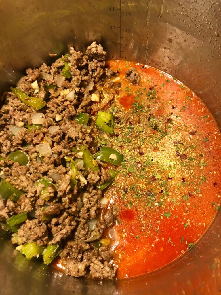 beef green pepper and onion added to tomato juice and diced tomatoes in pan with seasonings