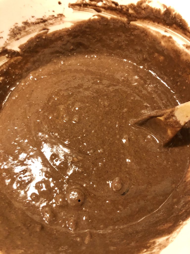 hot cocoa cupcake cake batter with packets of hot cocoa mix stirred in