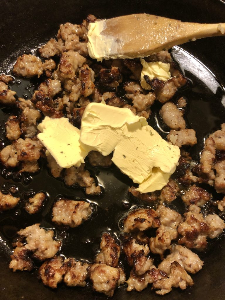 cooked Italian sausage in skillet with butter and olive oil
