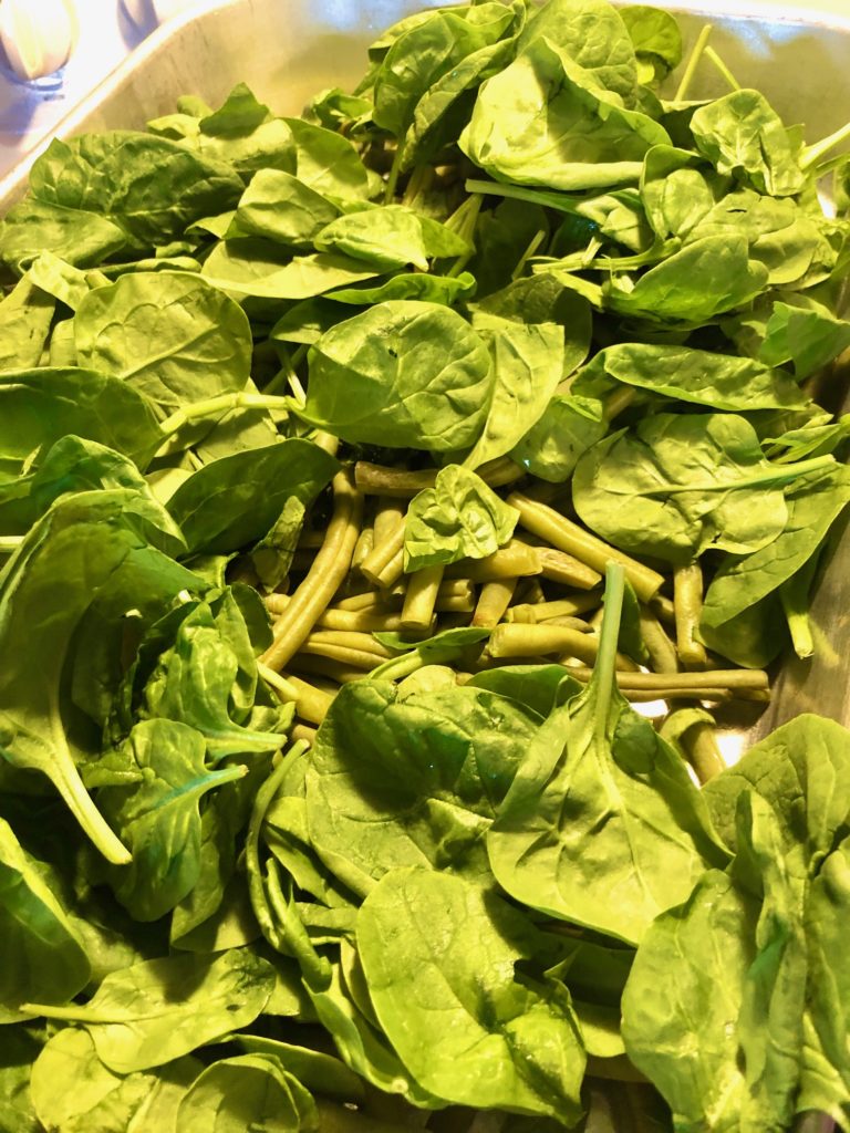 green beans in pan with baby spinach added