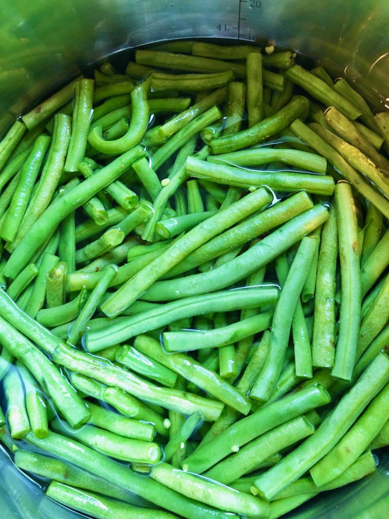 green beans in pot of water with salt before boiling