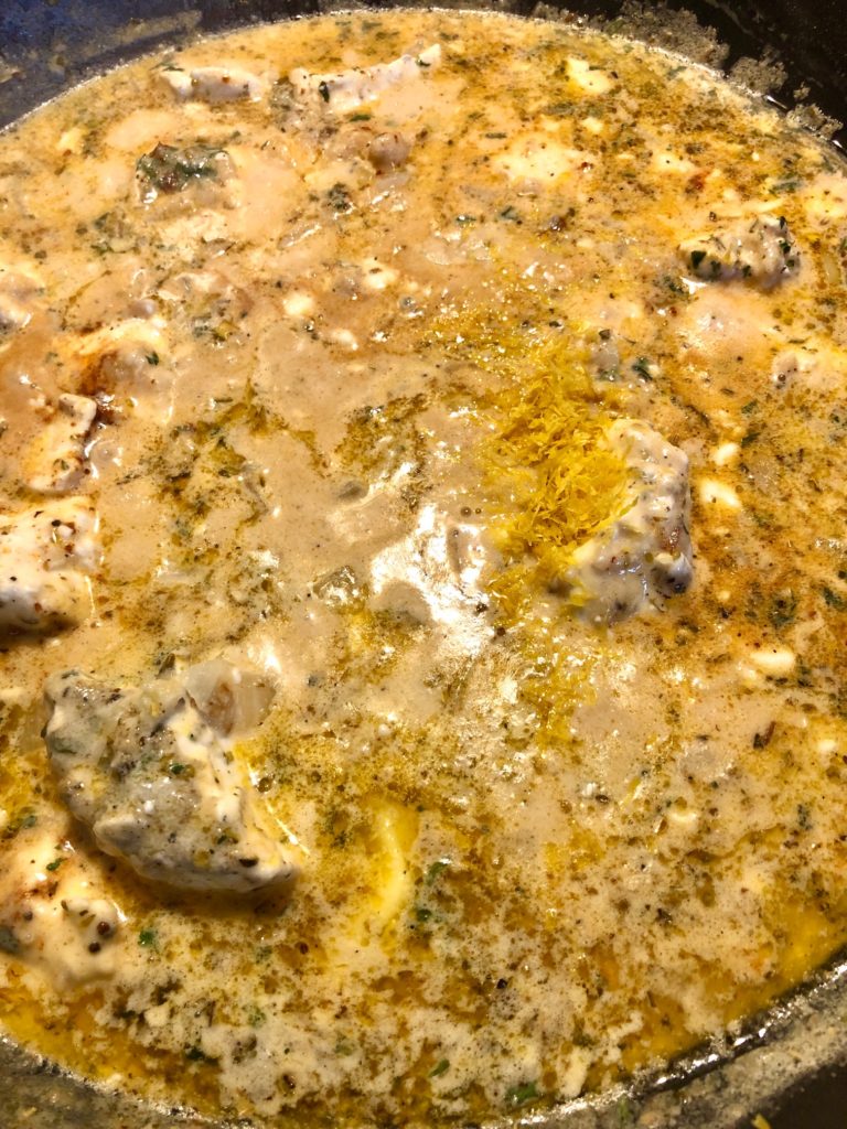 cream sauce being prepared on stovetop. milk, butter, lemon zest, cream cheese and seasonings