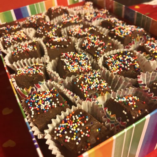 Rainbow sprinkle chocolate fudge in truffle wrappers in decorative box