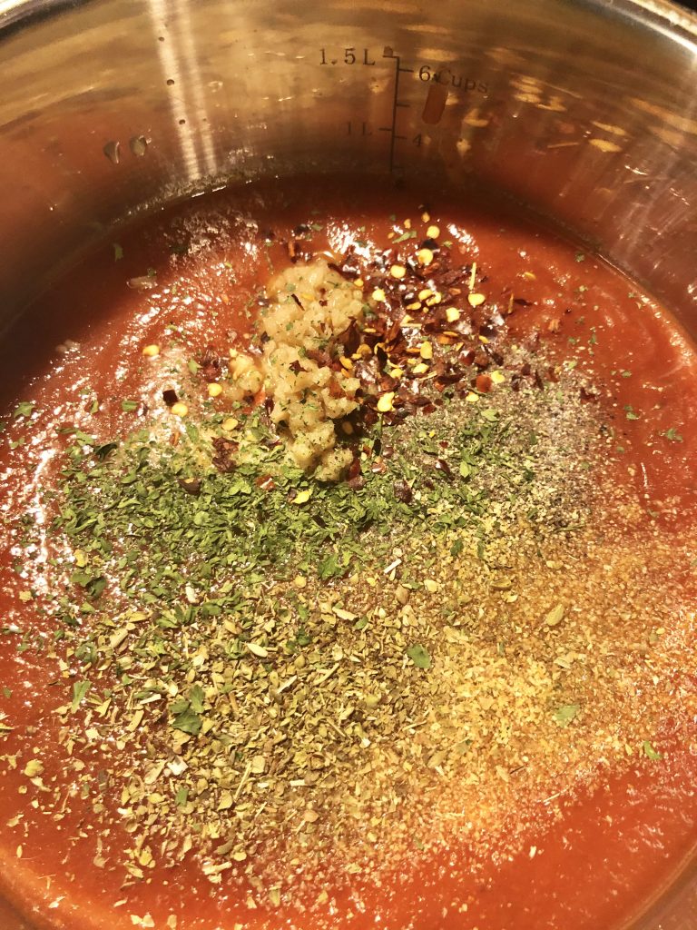 chicken parm spaghetti sauce in pot with seasonings