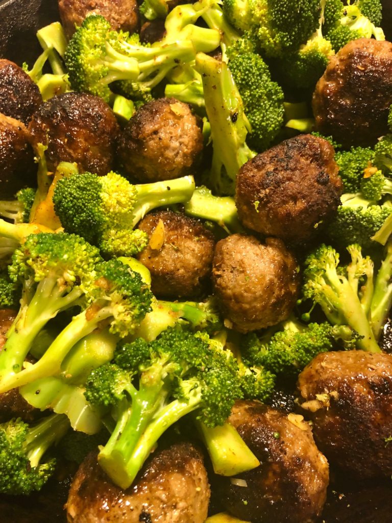 Korean meatballs and broccoli frying in cast iron skillet