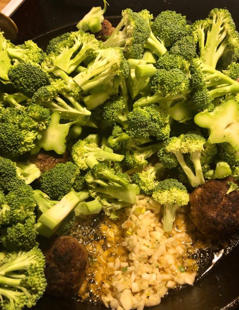 add broccoli and garlic and ginger to cast iron skillet of frying meatballs