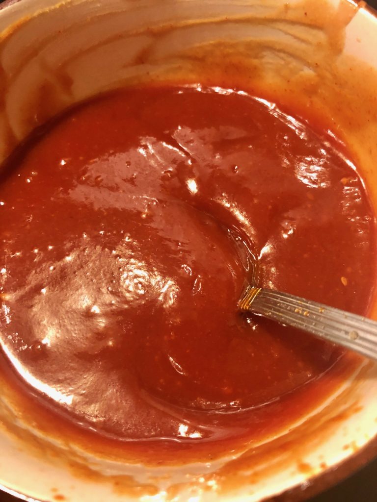 gochujang, sesame oil, rice wine vinegar, brown sugar and ketchup sauce stirred together in bowl