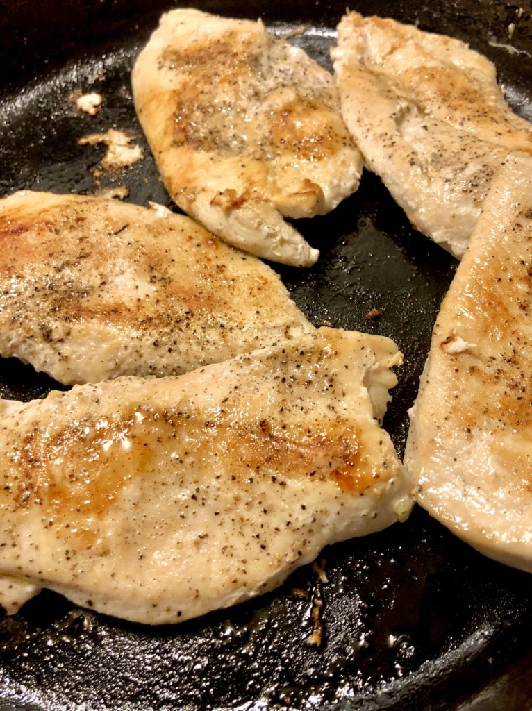 chicken breast cooking in skillet