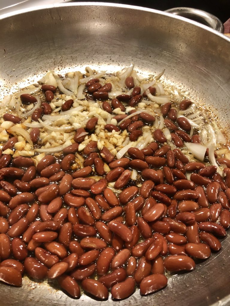 spanish rice garlic onion and beans frying