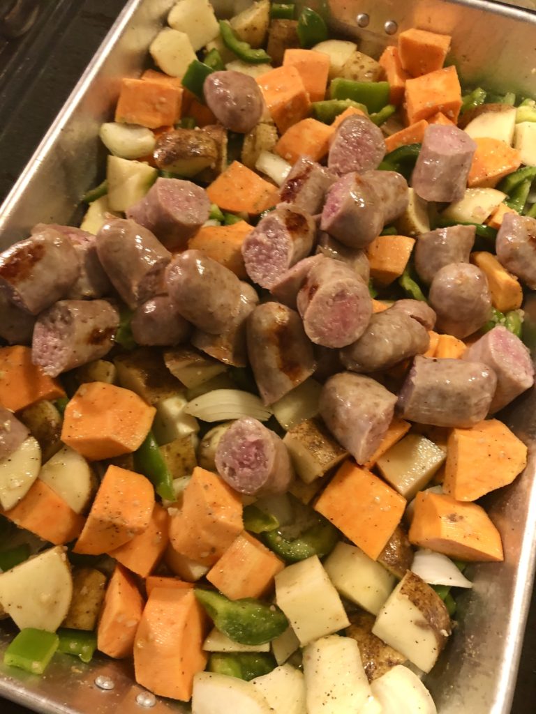 half cooked italian sausage over roasted veggies
