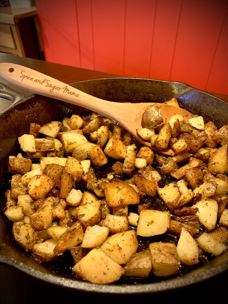 skillet breakfast potatoes cooking stovetop in castiron