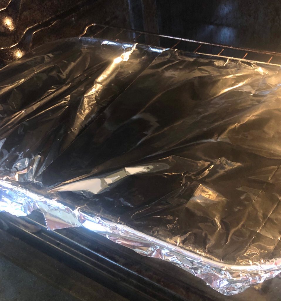 lasagna pan covered tightly with aluminum foil in oven
