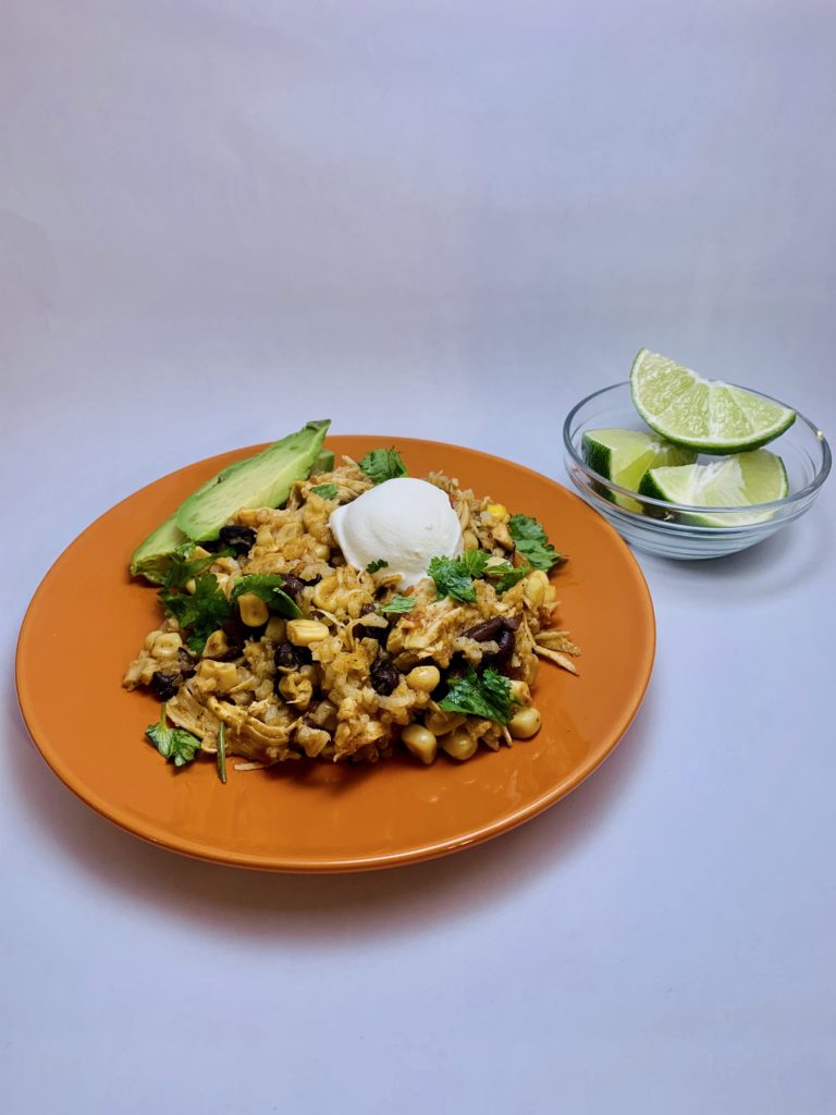 slow cook mexican shredded chicken and corn plated with sour cream and avocado