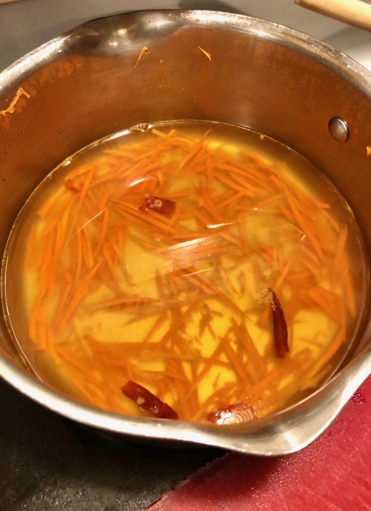 nuoc cham vietnamese fish sauce with shredded carrots and thai chilis in silver saucepan