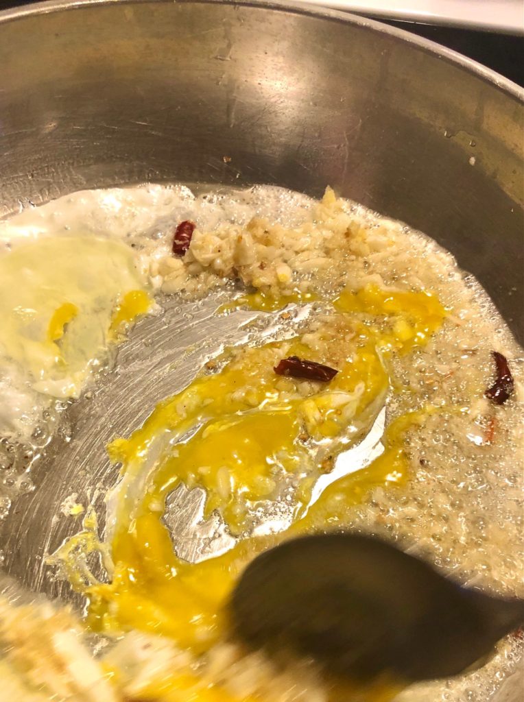 garlic, ginger, thai chilis and eggs scrambling in frying pan