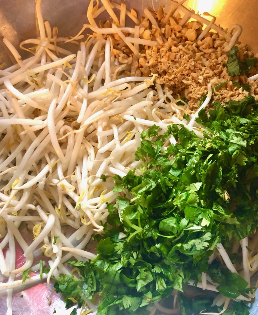 bean sprouts, cilantro and chopped peanuts in metal mixing bowl