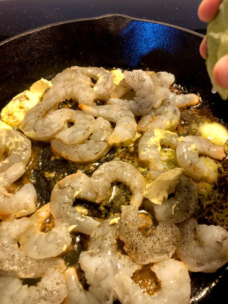 shrimp and butter cooking in cast iron skillet
