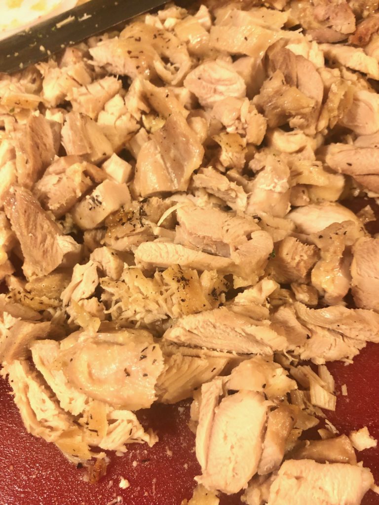 sliced boneless skinless chicken breast on cutting board
