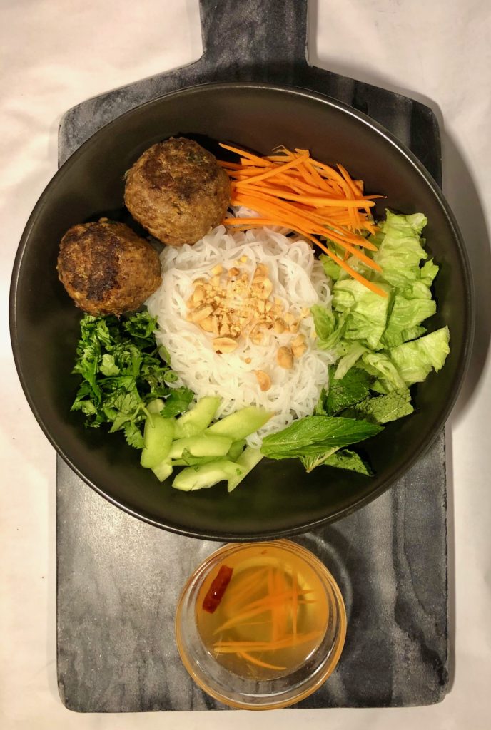 overhead photo of thai meatballs in a vietnamese bun bowl and served with vietnamese fish sauce with shredded carrots