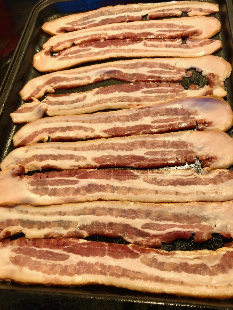 sliced bacon on black baking pan