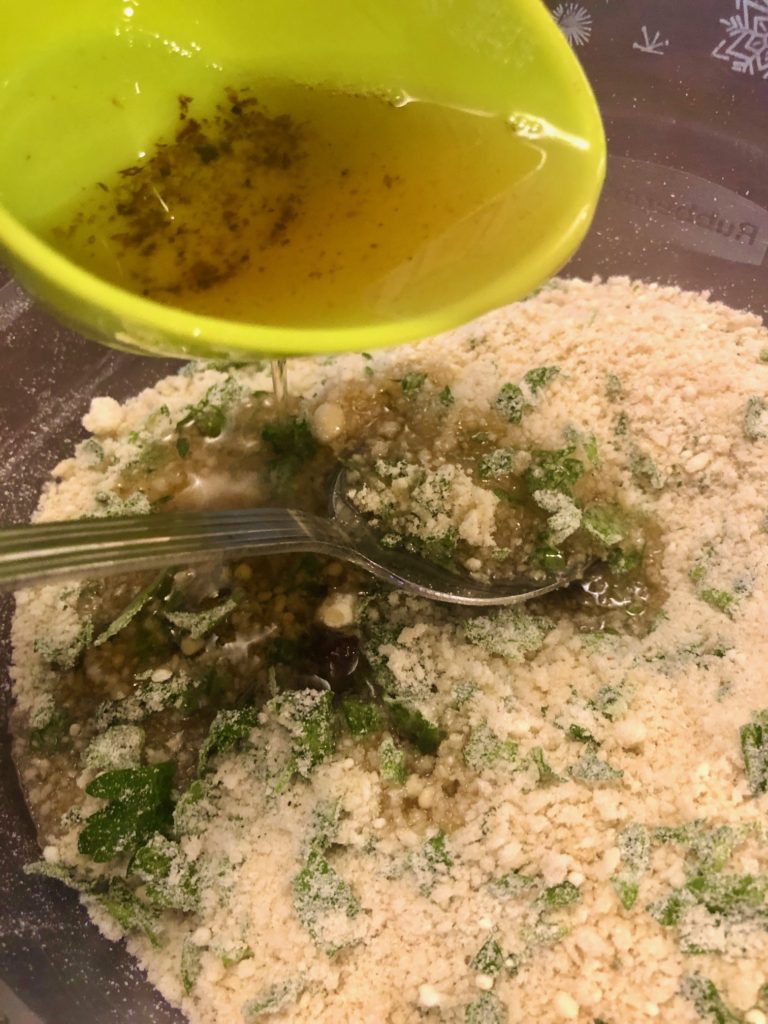 panko breadcrumbs, fresh parsley, grated parmesan cheese with bacon grease being drizzled in. bacon grease is pictured in green mixing cup and breadcrumbs are being mixed with a silver spoon