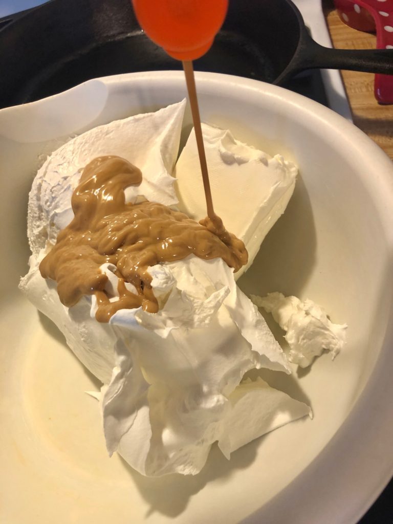 cream cheese, cool whip and Reese's peanut butter topping in white medium mixing bowl