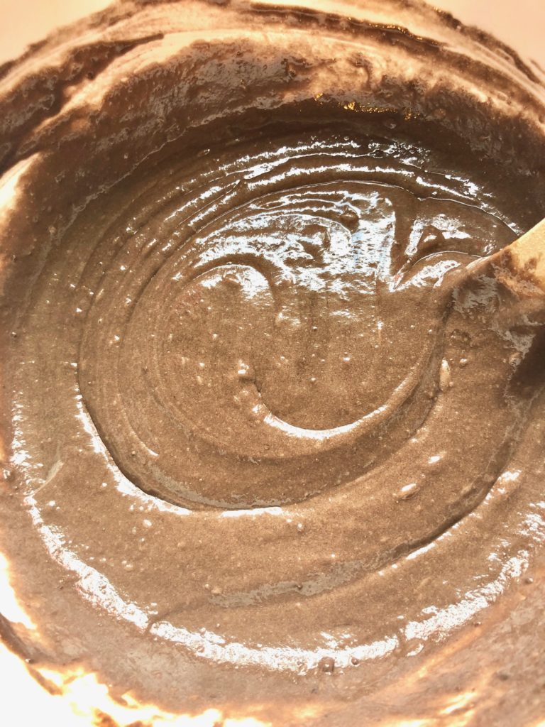 prepared chocolate cake batter in a white mixing bowl