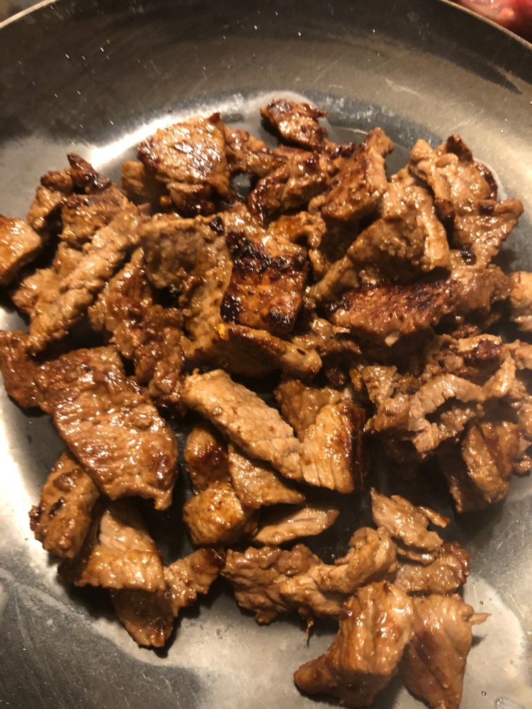 cooked flank steak slices set aside on plate