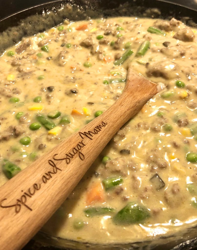 creamy mixture with milk, butter, cream of mushroom and mixed veggies stirred together in cast iron skillet