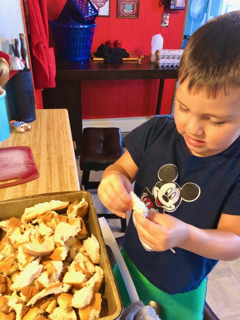 Dylan tearing apart day old bread for french toast casserole