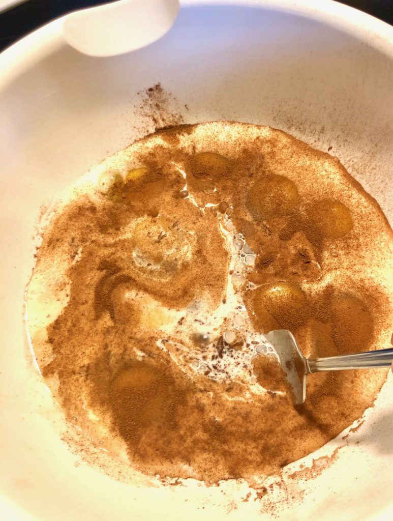 french toast egg mixture being beaten in large white mixing bowl