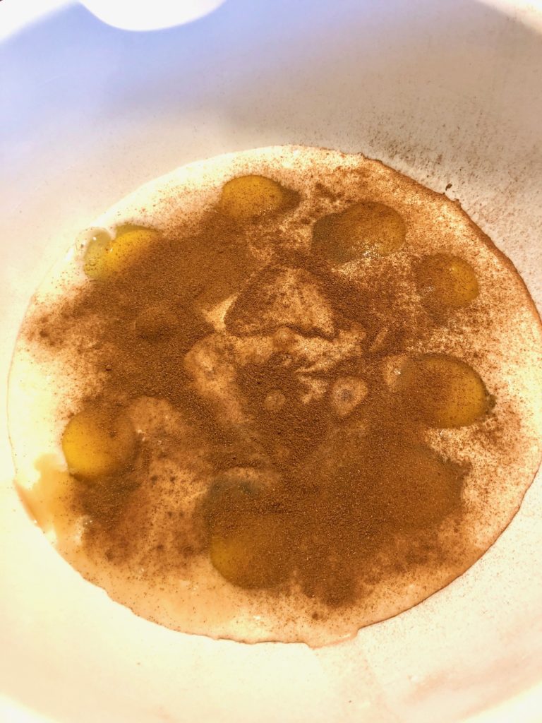 eggs, milk, cinnamon and maple syrup in large white mixing bowl