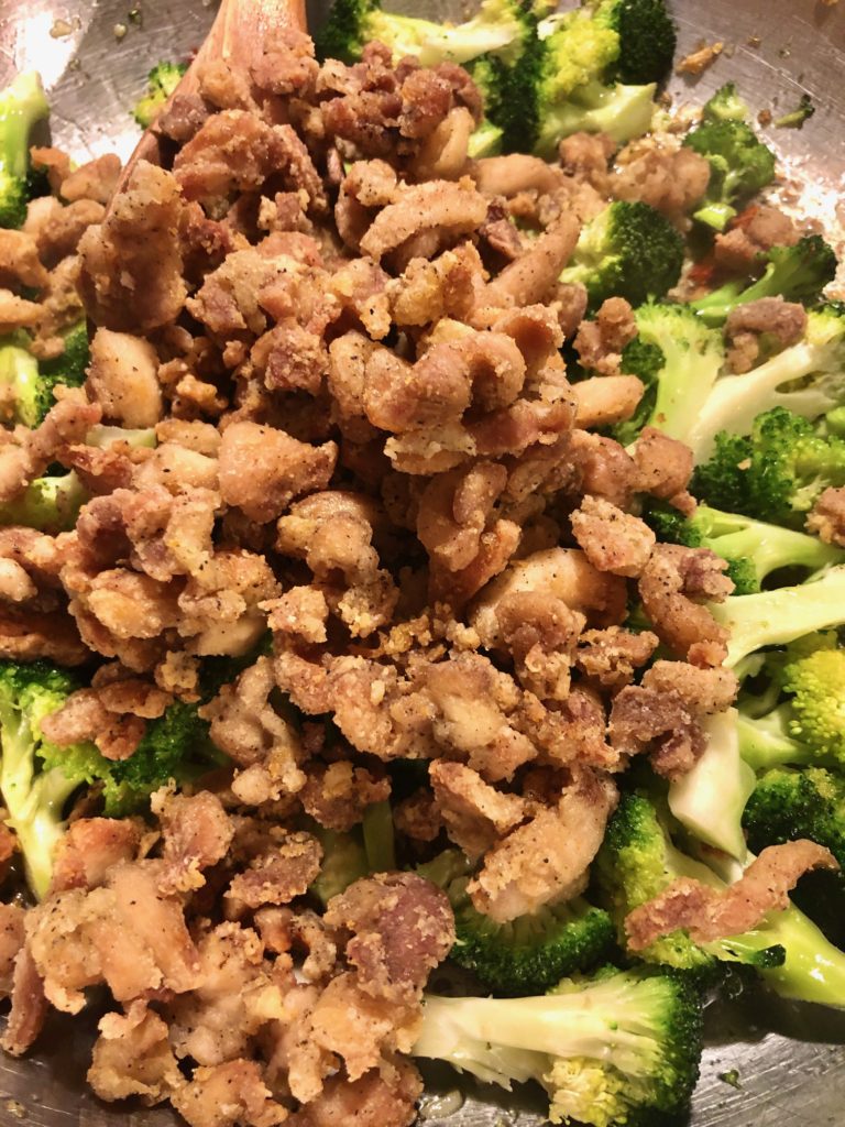fried boneless skinless chicken with broccoli in silver frying pan