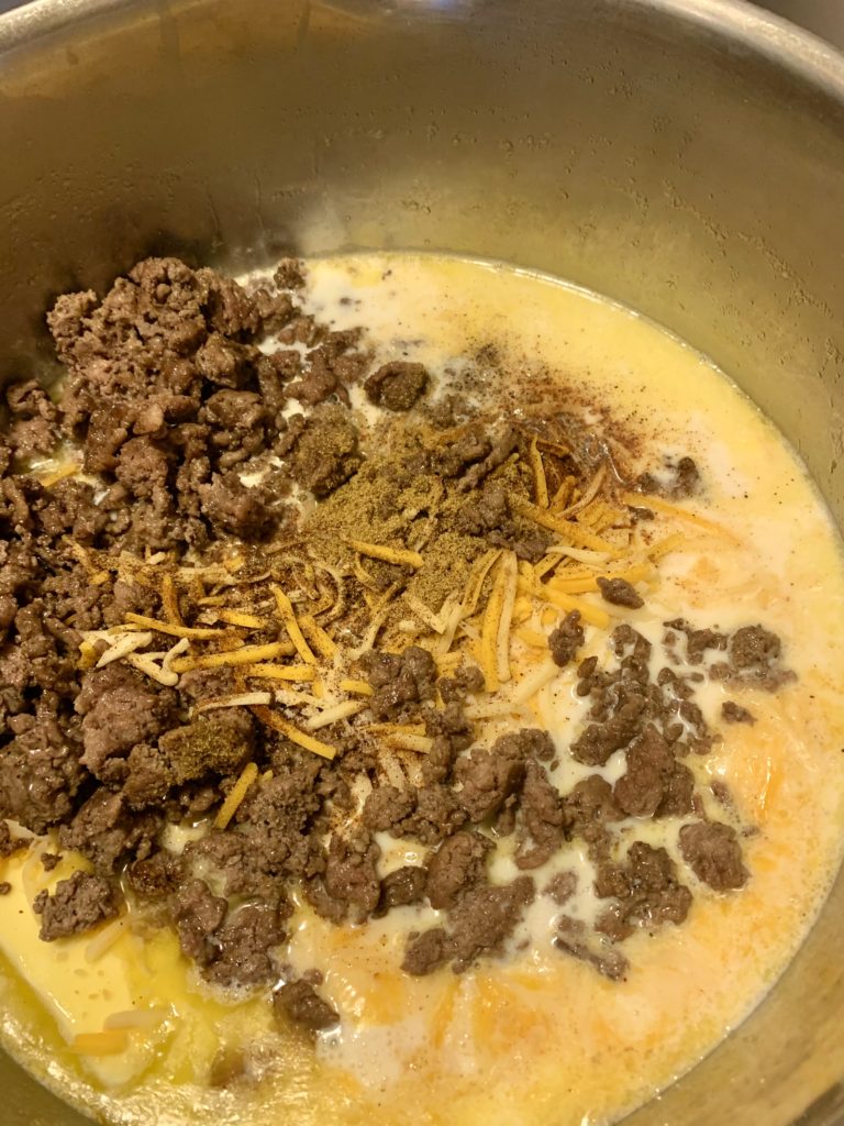 milk, butter, shredded cheese, salsa, ground beef and taco seasonings in pot