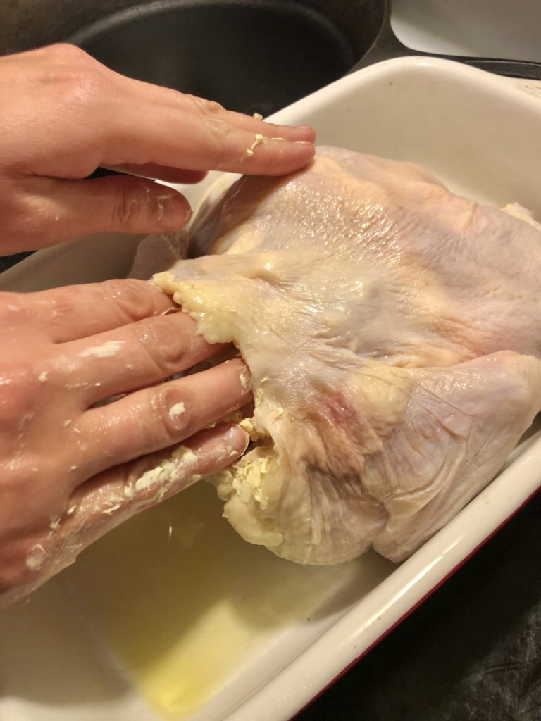 spreading the butter spread and minced garlic mixture around under the skin