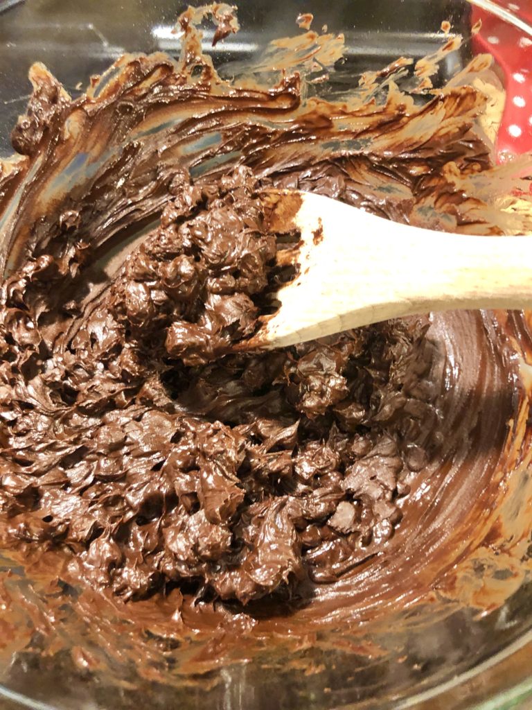 stirring chocolate chips that are melting in double boiler to make fudge