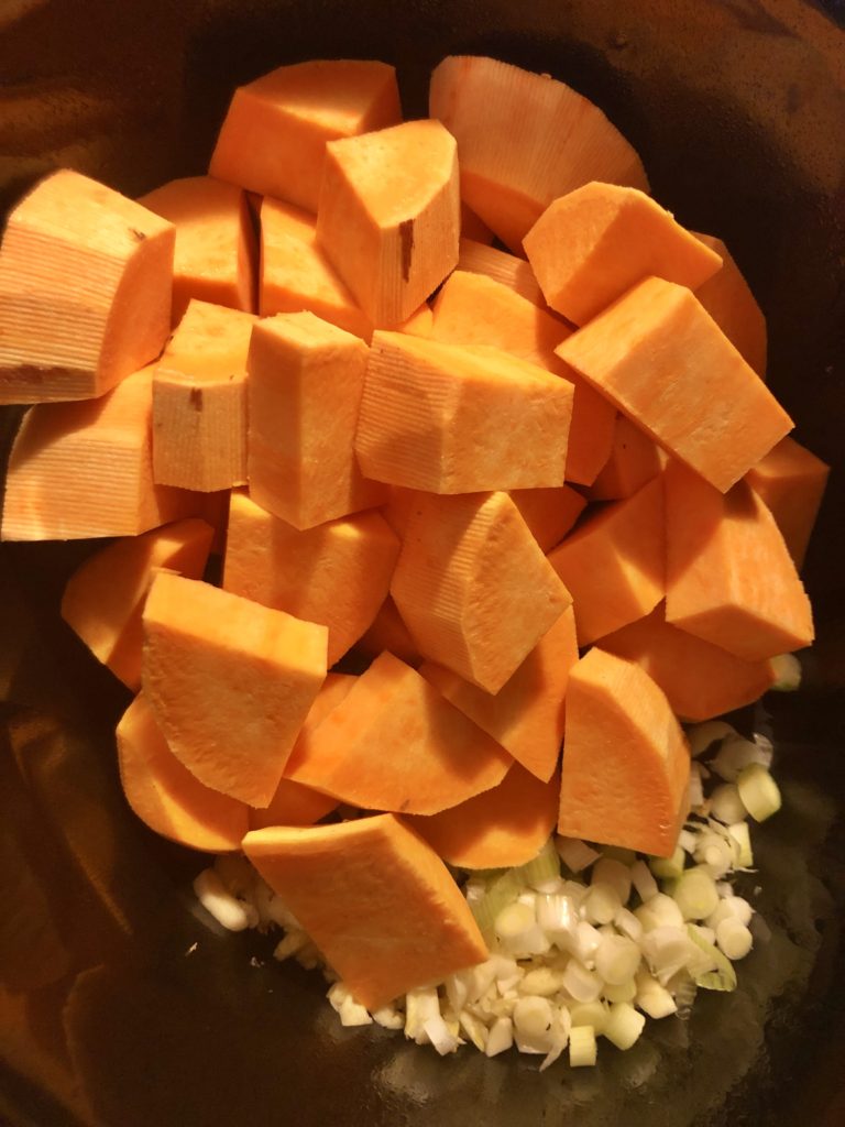 garlic and green onion with sweet potatoes in slow cooker pot
