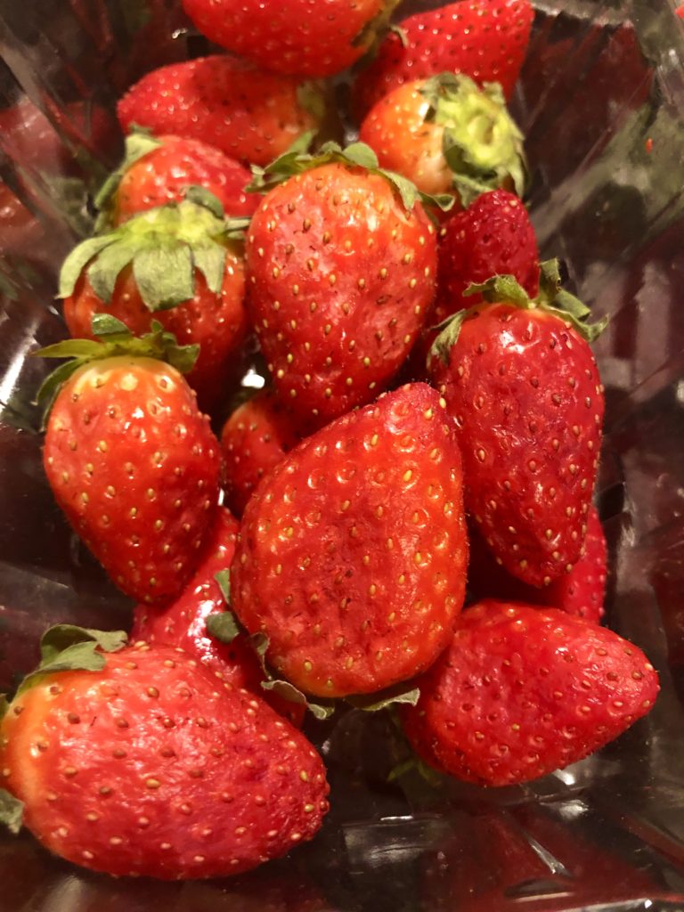 Overripened strawberries in clear plastic container