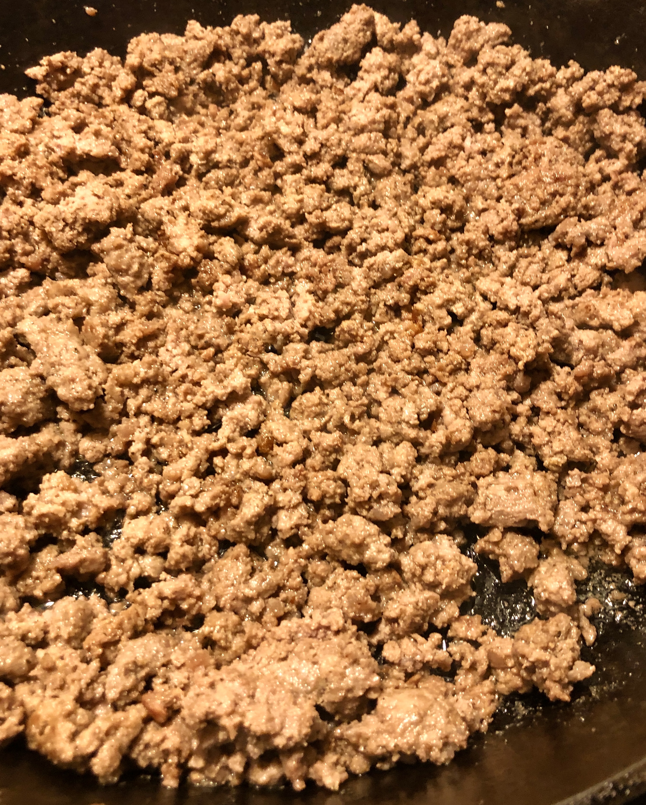 Cooked ground beef in cast iron skillet.