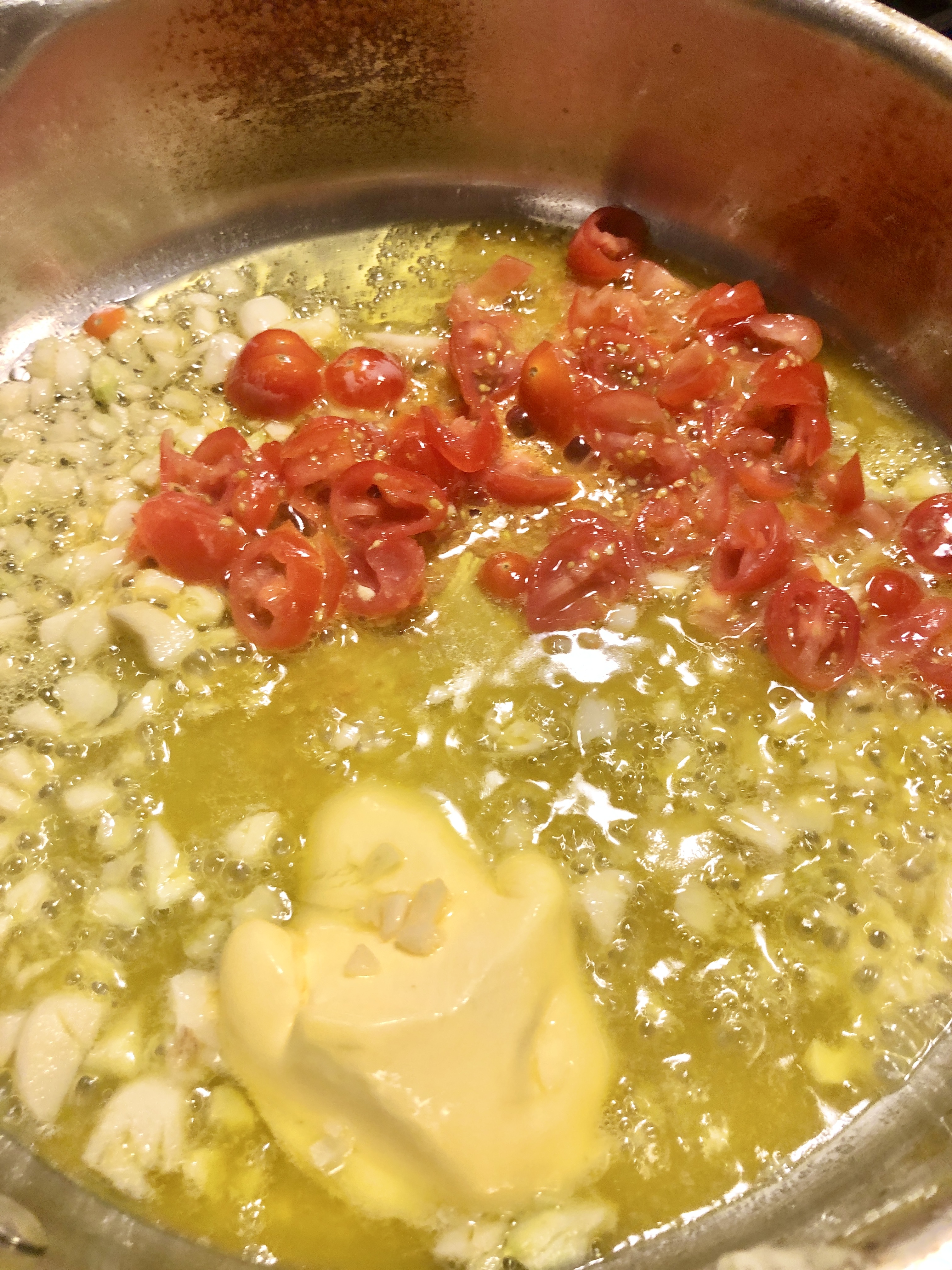 Olive oil, butter, garlic, cherry tomatoes and grated parmesan in a saucepan.