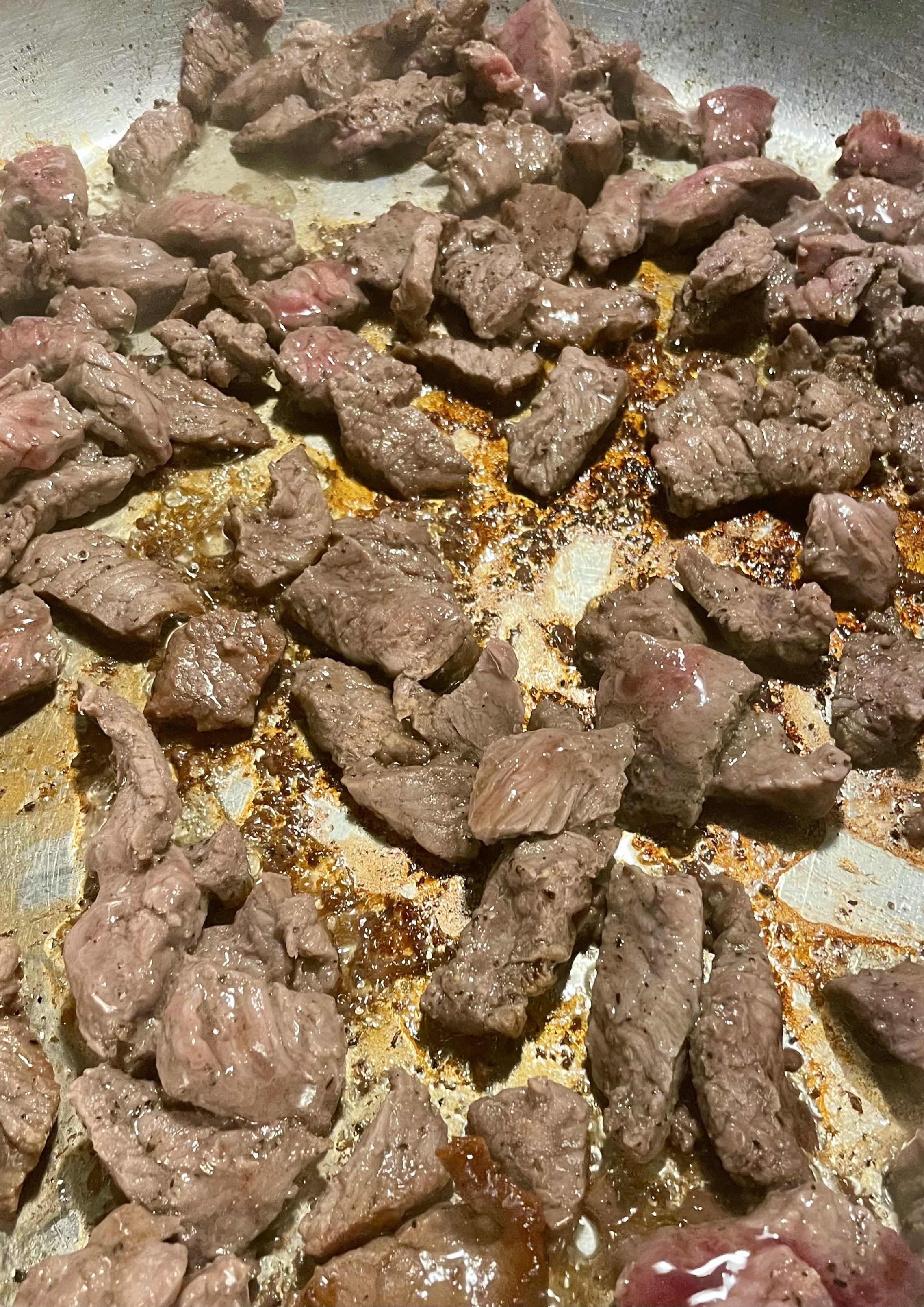 Thin sliced angus steak cooking in a pan.