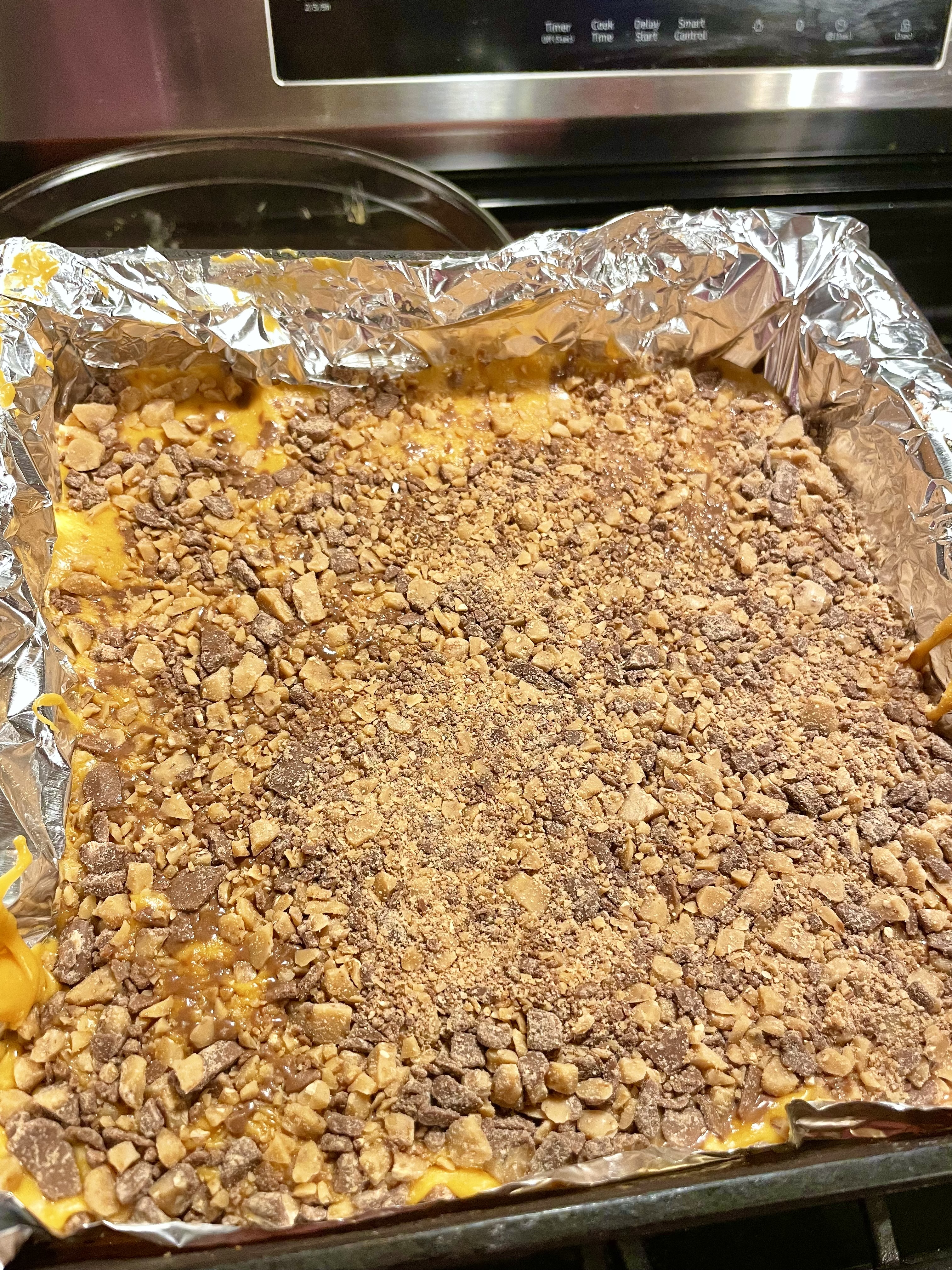 Butterscotch fudge with Heath Candy topping setting in baking dish prior to being cut.
