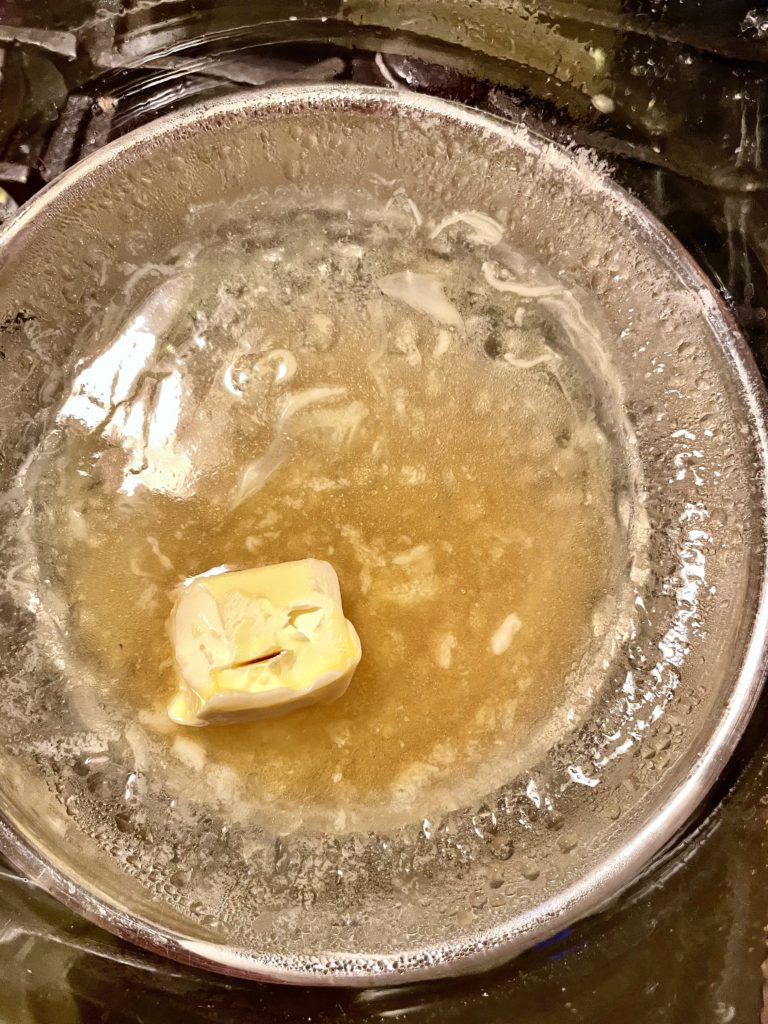 Butter and vanilla extract melting in homemade double boiler. 