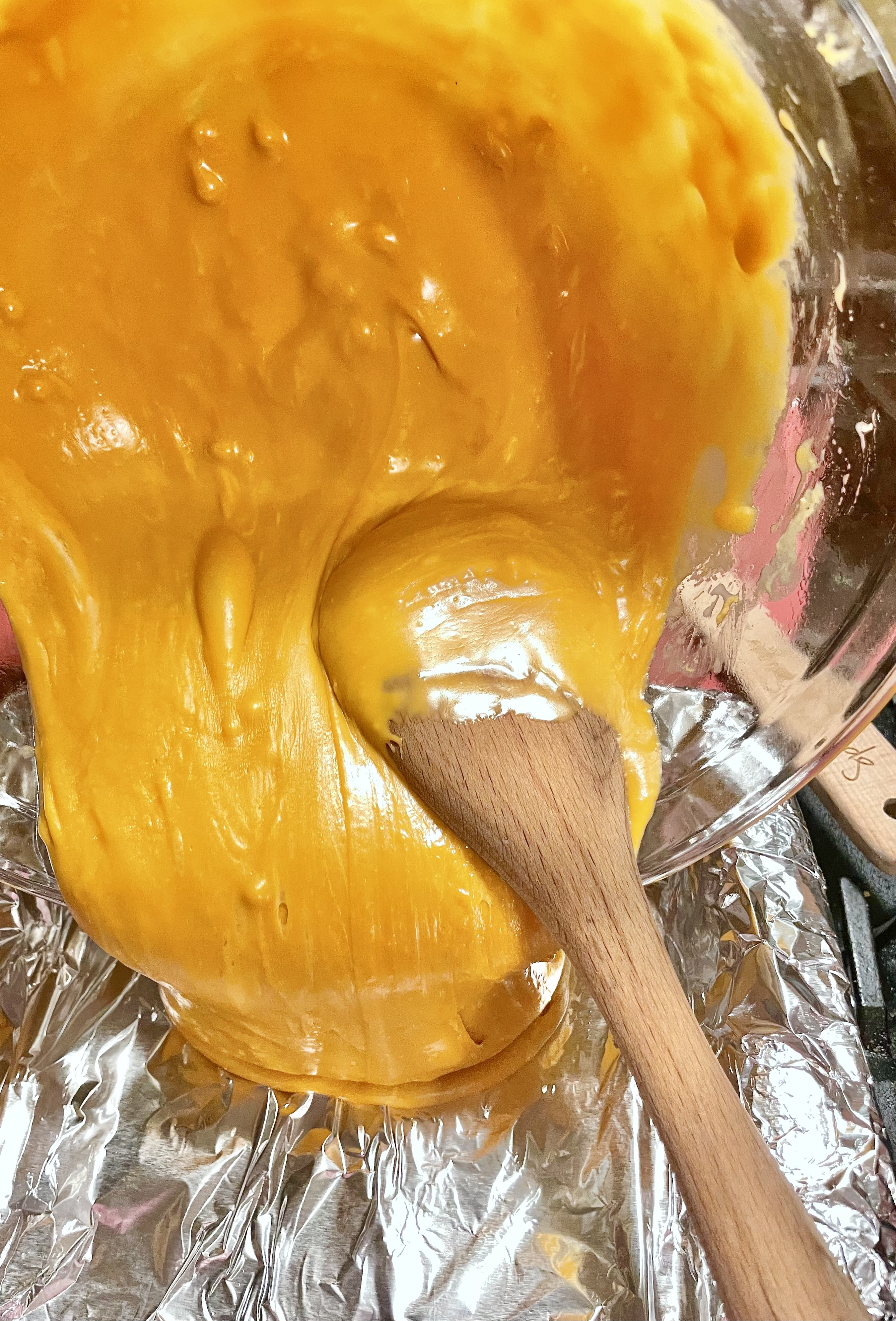 Butterscotch fudge being poured into foil lined 8x8 pan prior to setting in refrigerator.