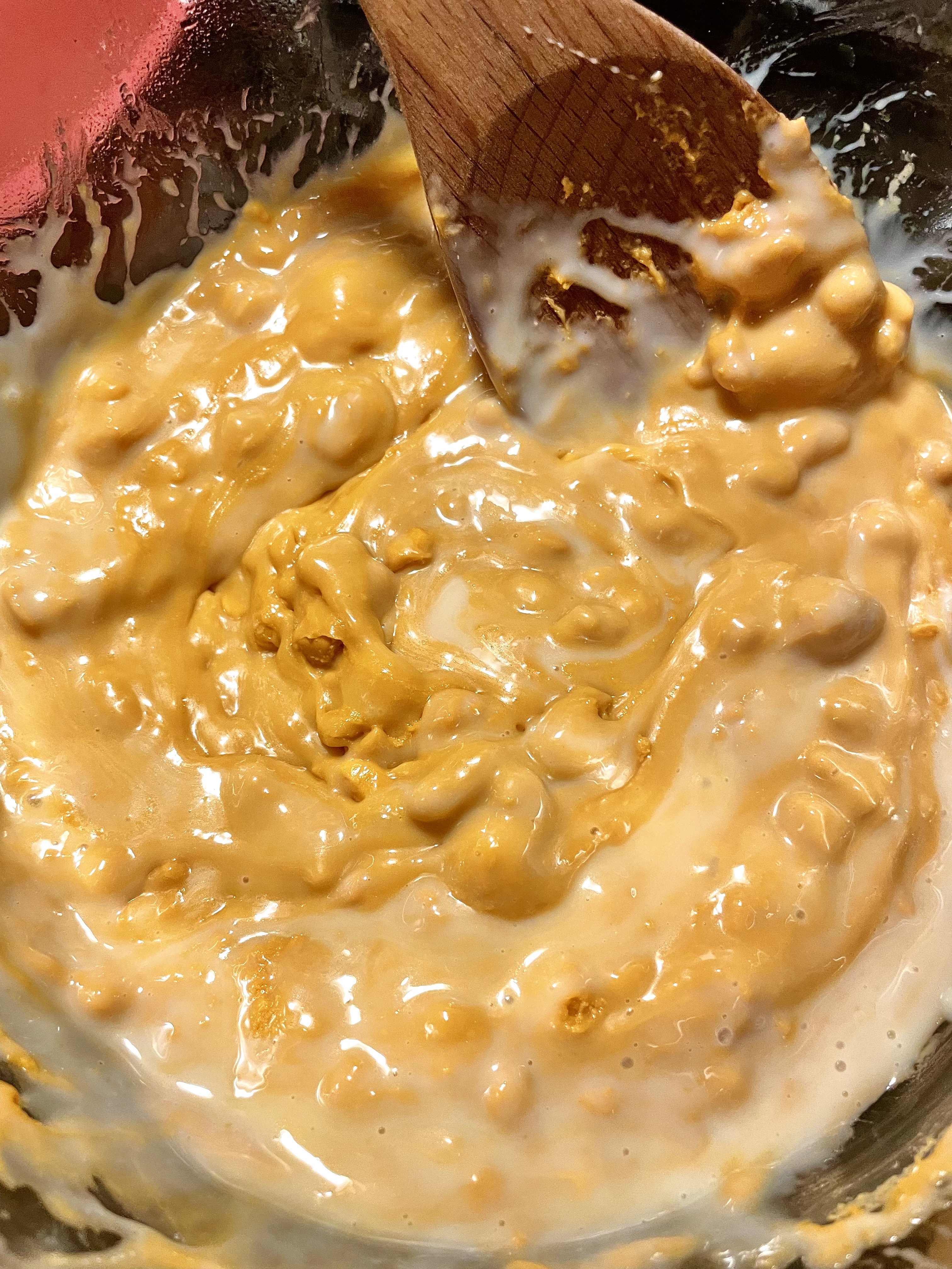 Sweetened condensed milk mixing with melted butterscotch chips in a double boiler.