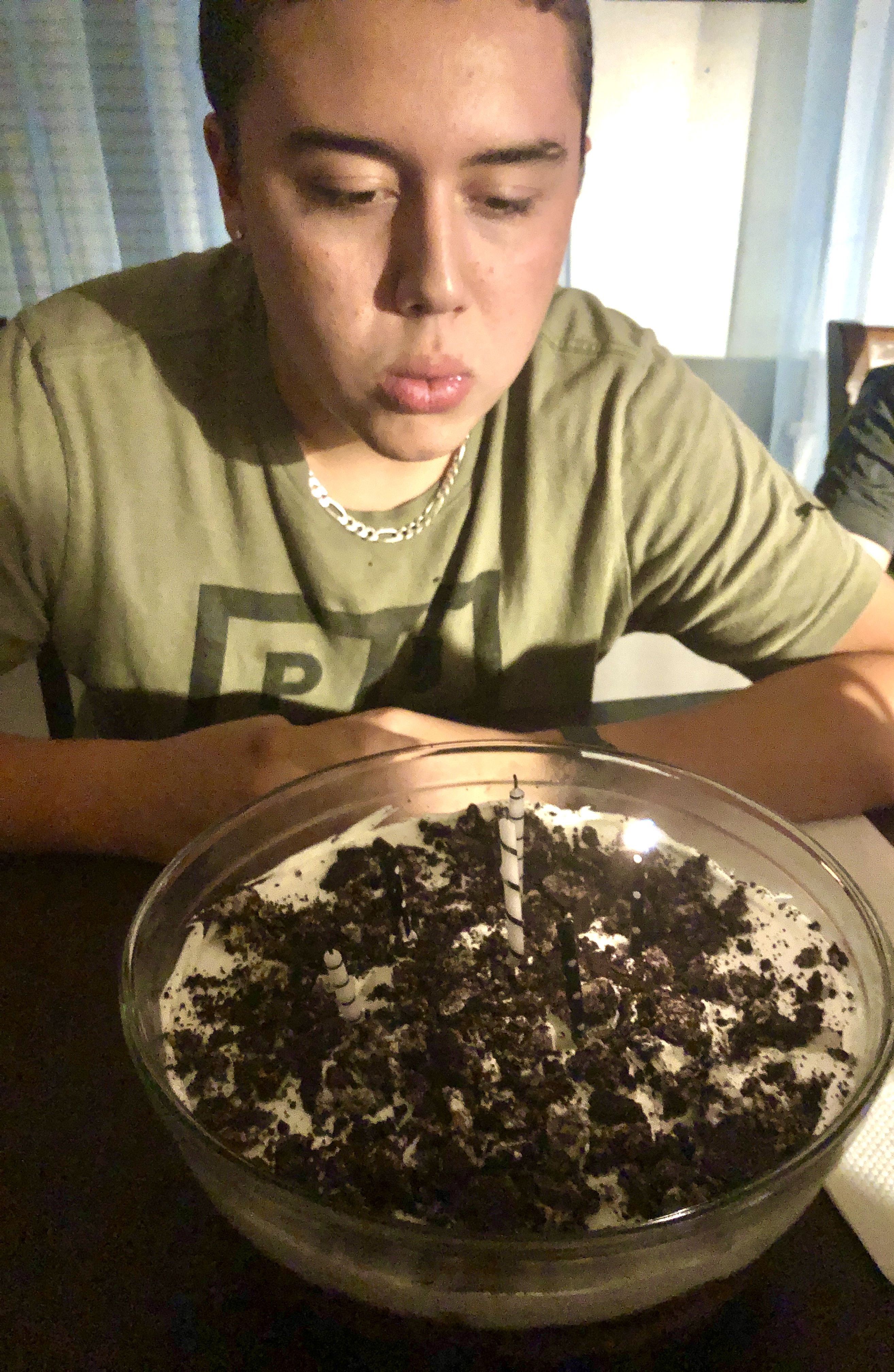 My son blowing out candles on his birthday Dirt Cake (Mud Bucket) dessert.