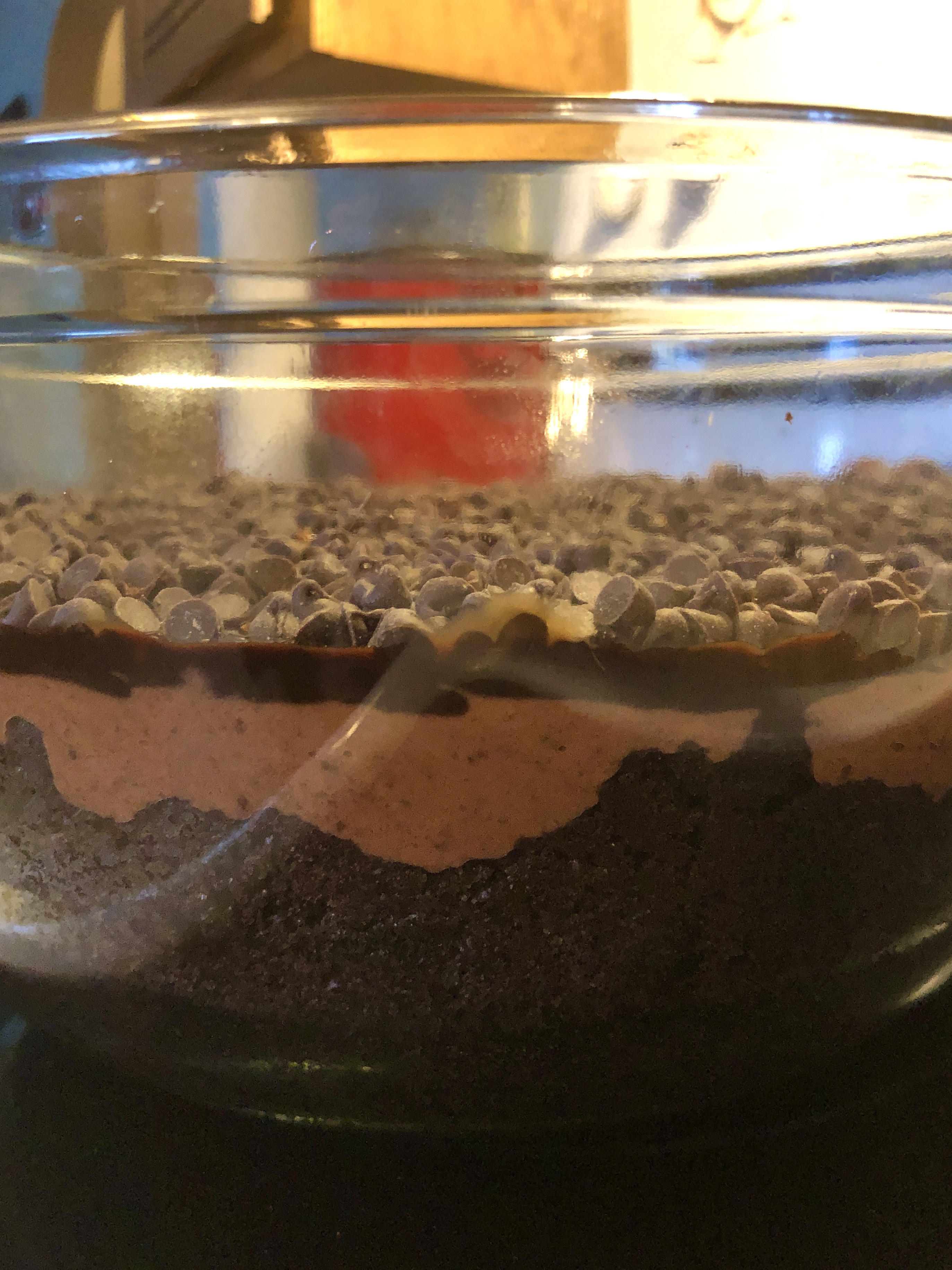Side view of trifle bowl showing layers of chocolate cake, chocolate pudding, chocolate syrup and chocolate mini chips.