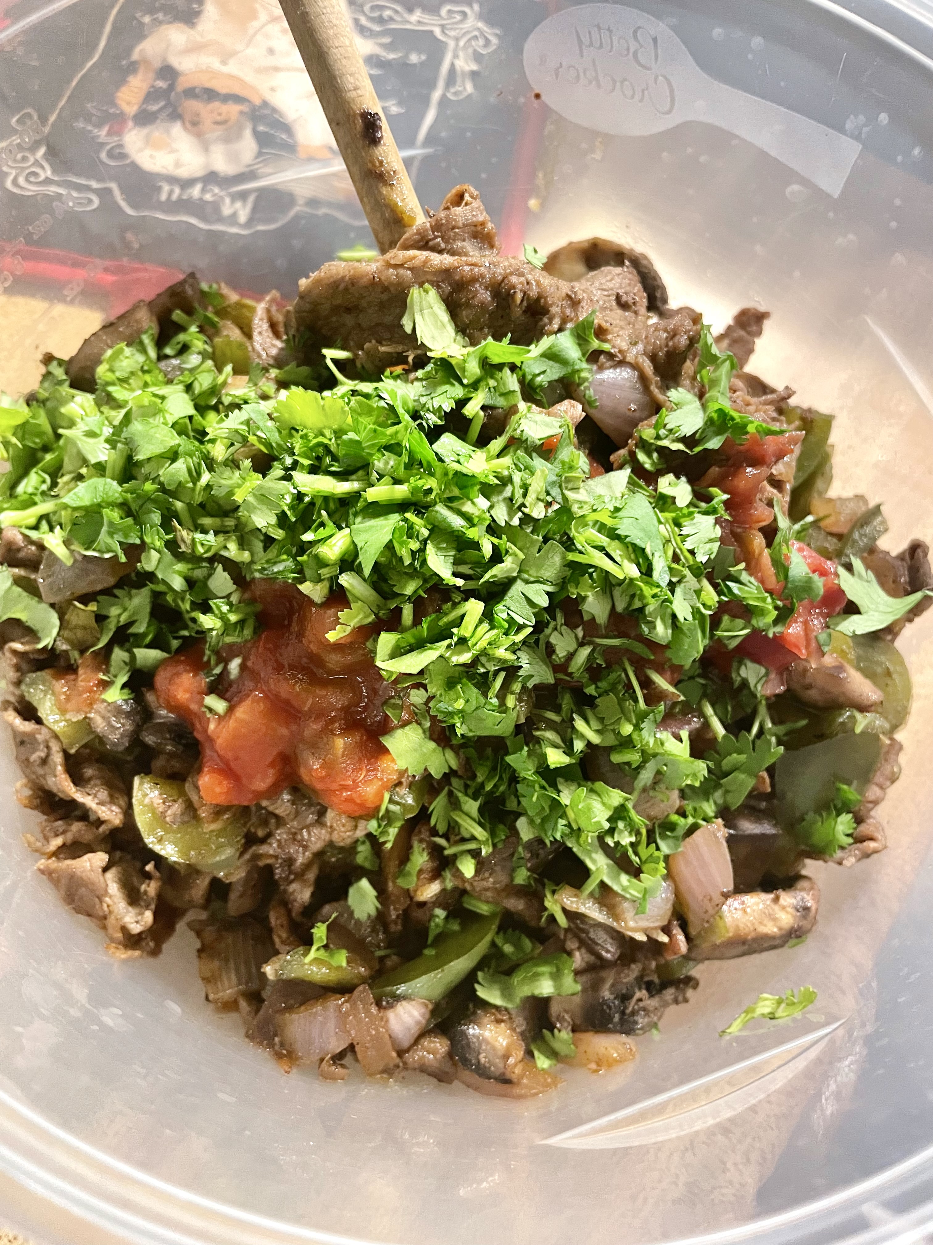 Steak bomb filling in mixing bowl with cilantro and salsa added.