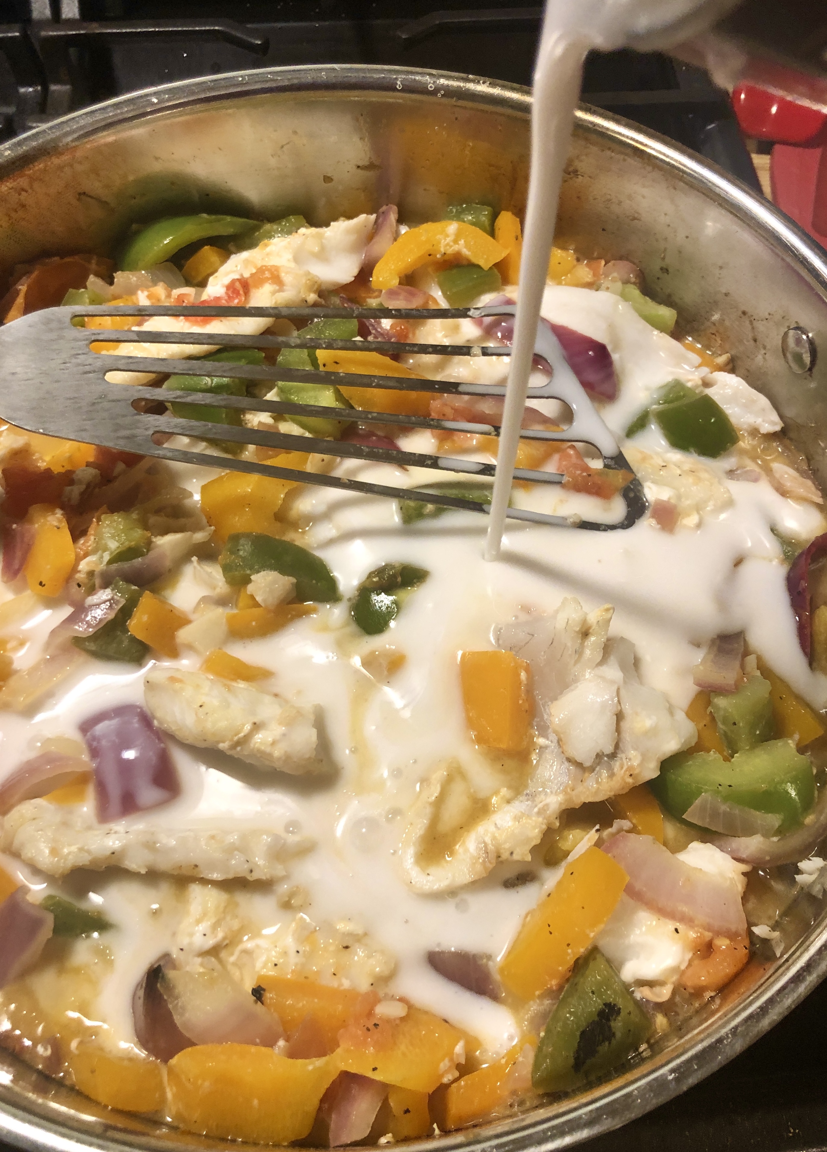 Unsweetened coconut milk being added for Moqueca recipe.